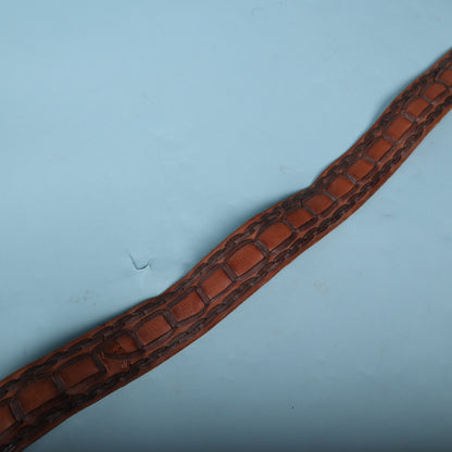 Diagonal view of woven brown leather strap detailing