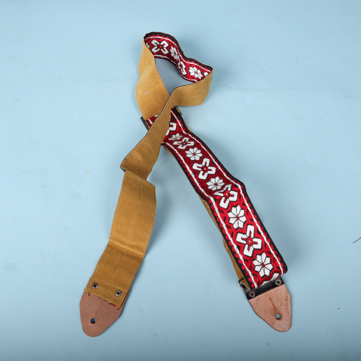 Rear view of the vintage 1960s woven guitar strap showing the tan backing and leather end tabs