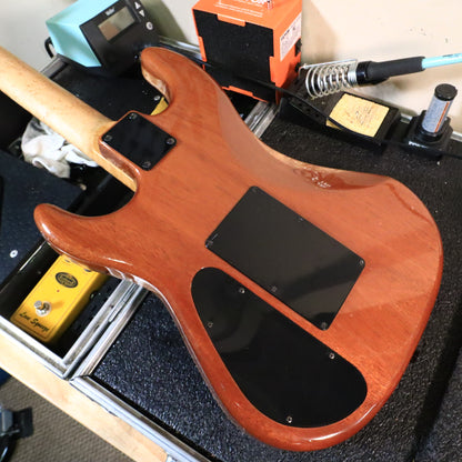 Back of natural finish guitar body showing neck plate and cavity covers.