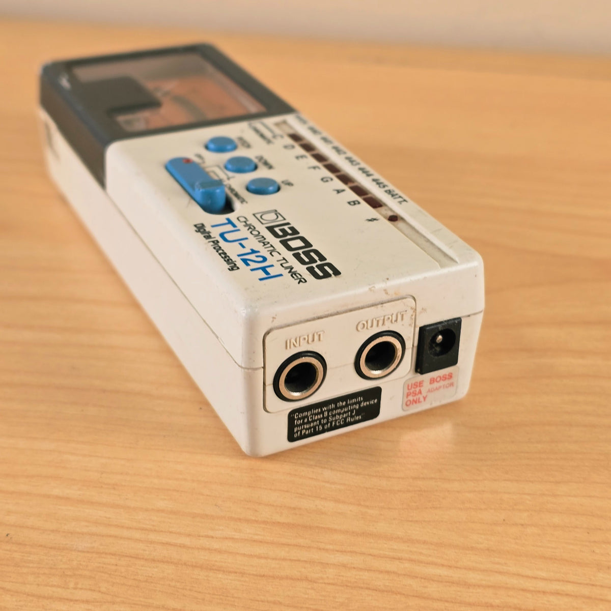 Close view of the input and output jacks and Boss PSA power label on the Boss TU-12H.