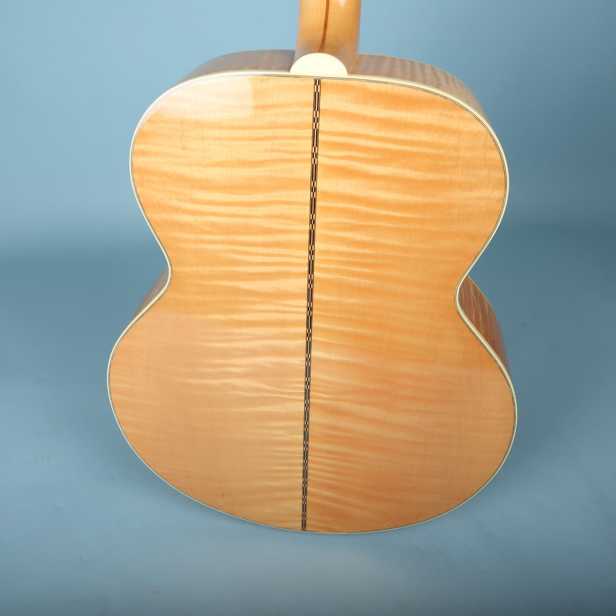 Angled back view showing flame maple wood grain and body binding.