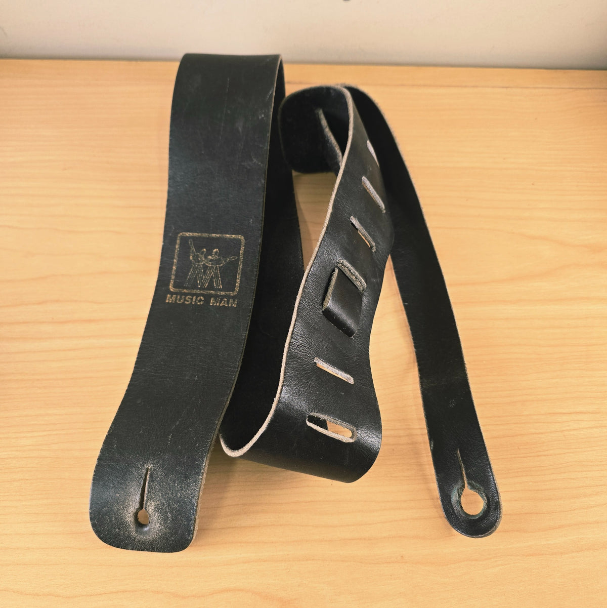 Vintage Music Man leather strap laid out on table showing button ends and slots