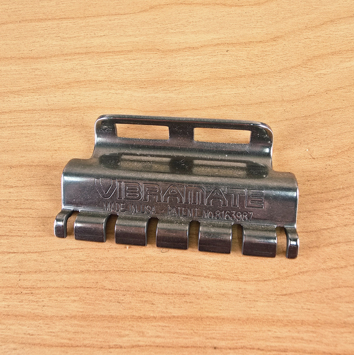 Top view of the Vibramate Spoiler string retainer showing the stamped brand name and US patent number.