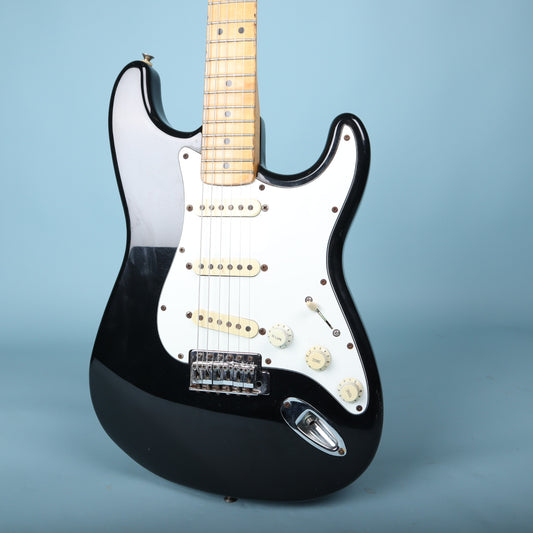 Front body view of black Squier Stratocaster with white pickguard