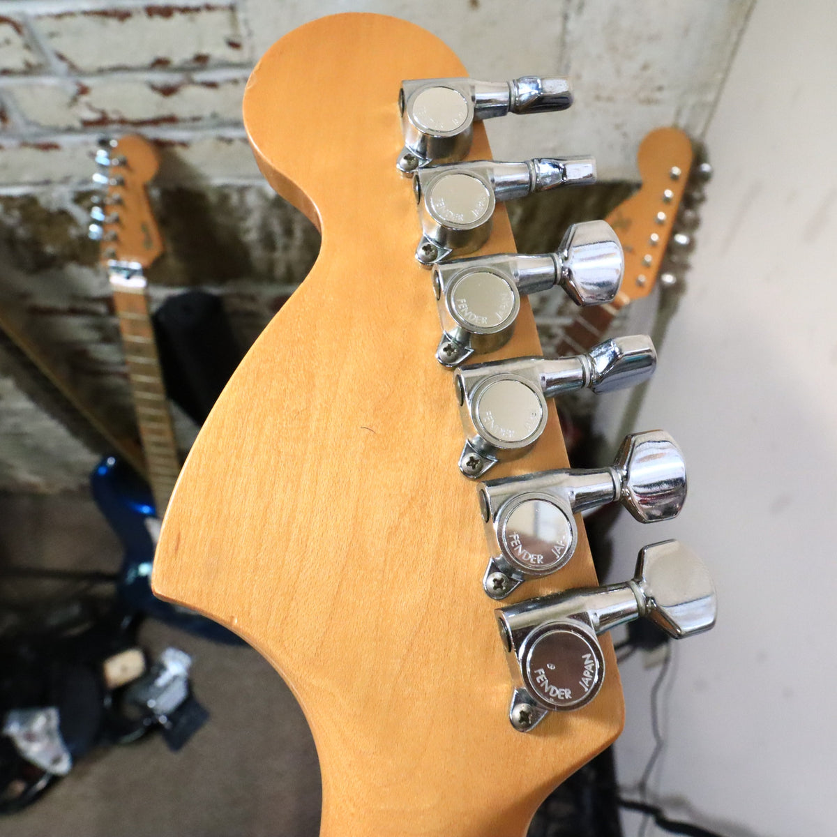Close-up of back of headstock showing Fender Japan stamped tuning machines.