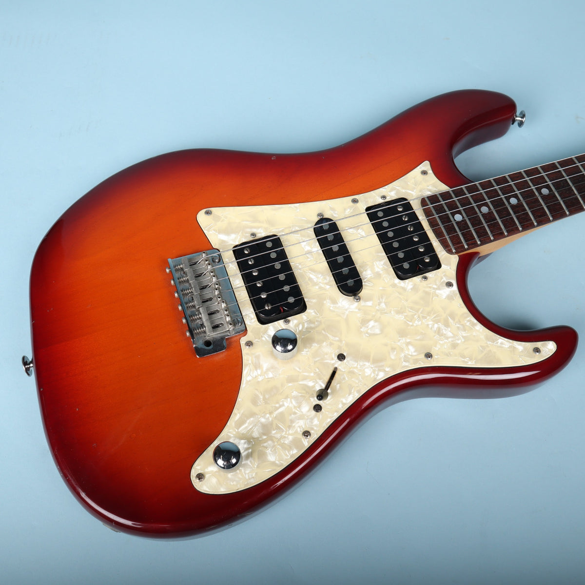 Angled view of lower body bout highlighting glossy red sunburst finish.