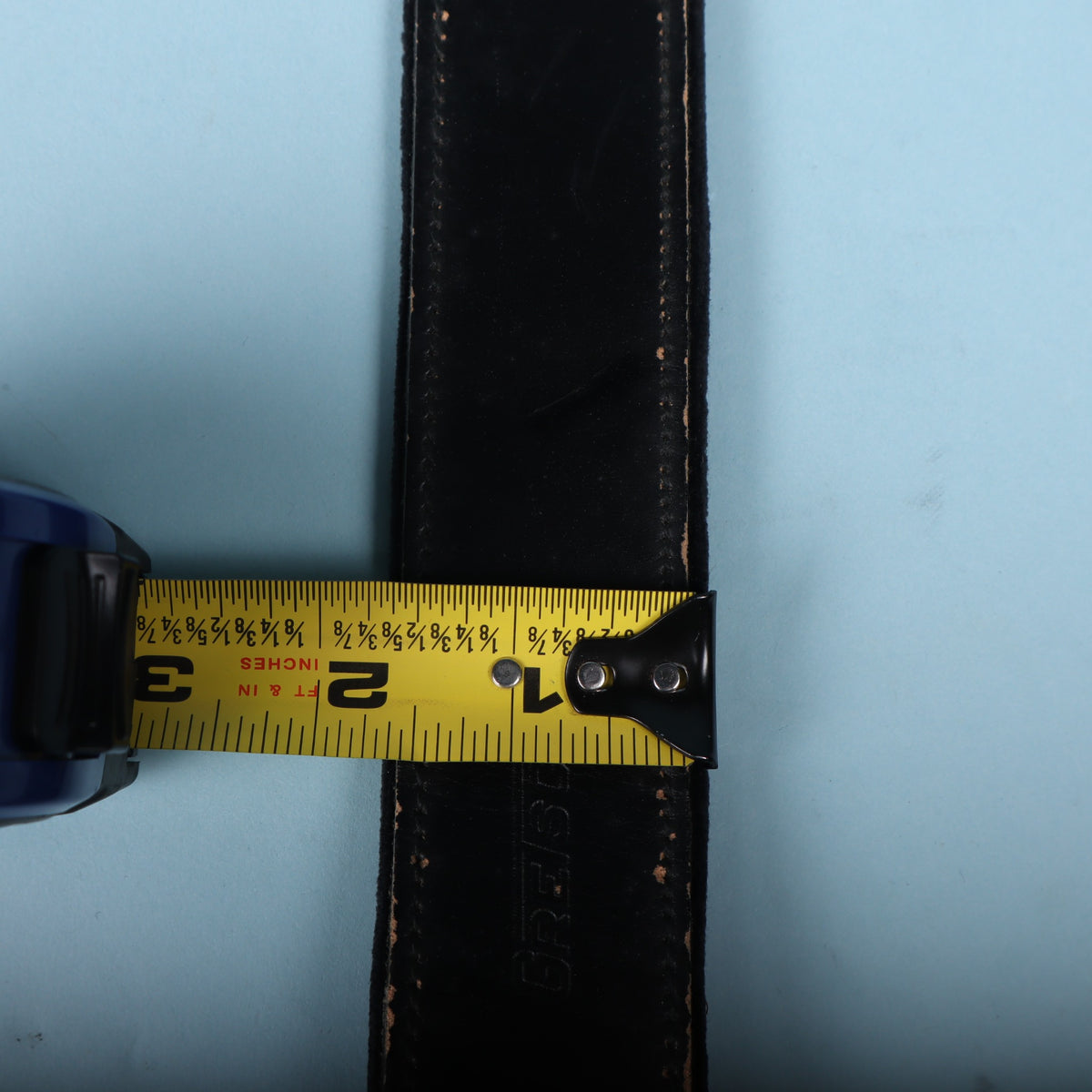 Tape measure displaying 2-inch width of Gretsch black leather strap.