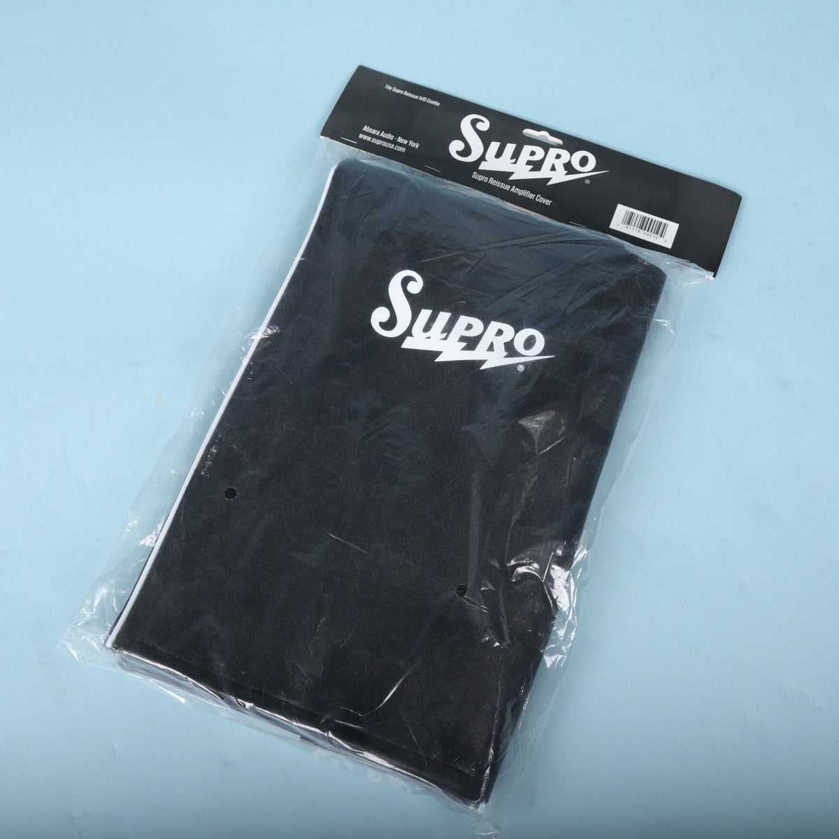 Front view of packaged Supro Reissue 1x10 combo amplifier cover in plastic packaging with header card.