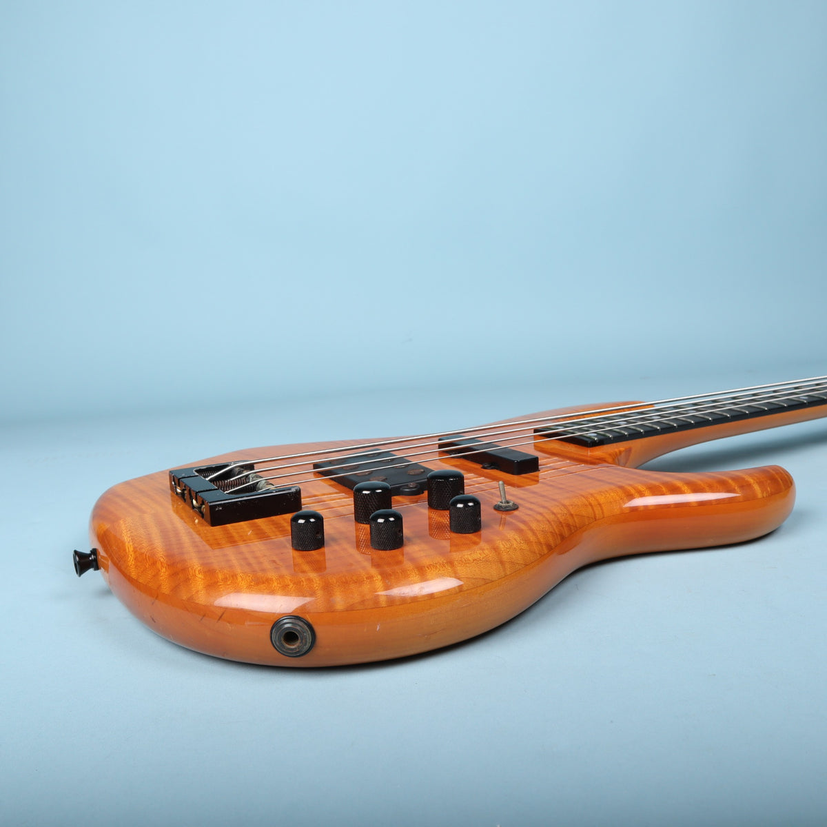 Treble-side rim profile showing the output jack and control knob layout.