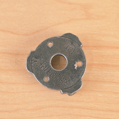 Reverse side of the Gunther guitar plate showing the central hole and stamped copyright and GUENTER markings.