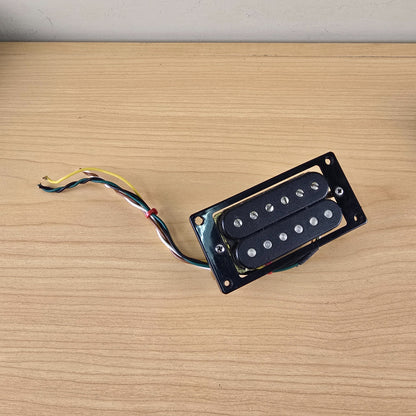 Overhead view of black Schaller humbucker showing coils, poles, and multi-conductor wire lead