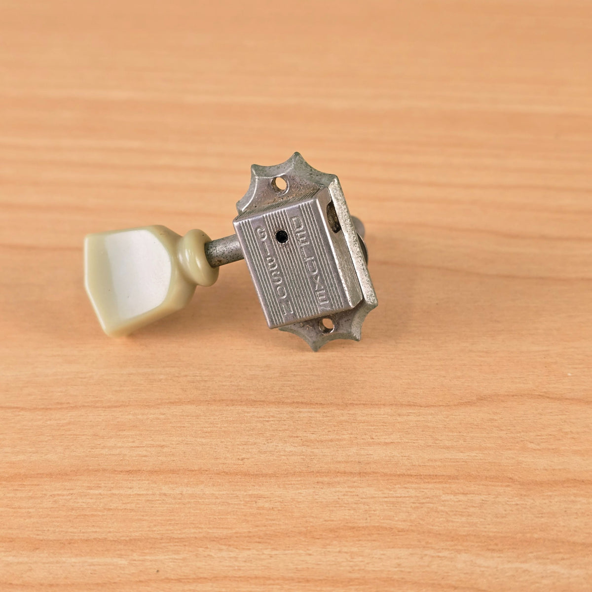 Rear view of 1994 Gibson Deluxe nickel tuning machine showing stamped casing and keystone button.