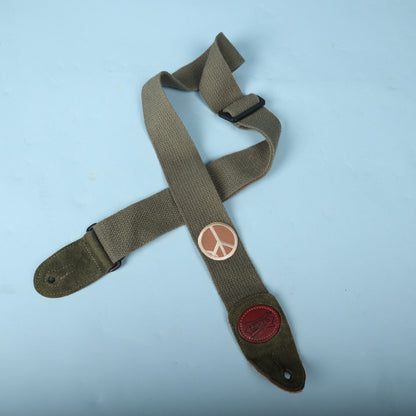 Levy's olive green cotton guitar strap with peace sign patch laid out flat