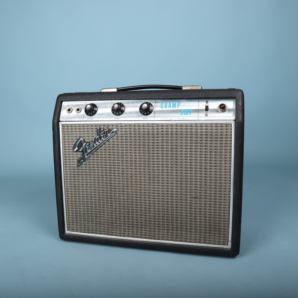 Top front angled view highlighting control knobs, input jacks, and carrying handle.