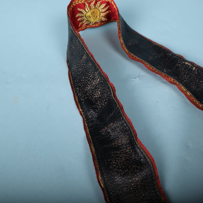 Underside and folded edge of a Levy's MPJG-SUN guitar strap showing backing wear