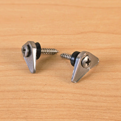 Pair of chrome triangular guitar string retainers with mounting screws and black spacers on a wood surface.