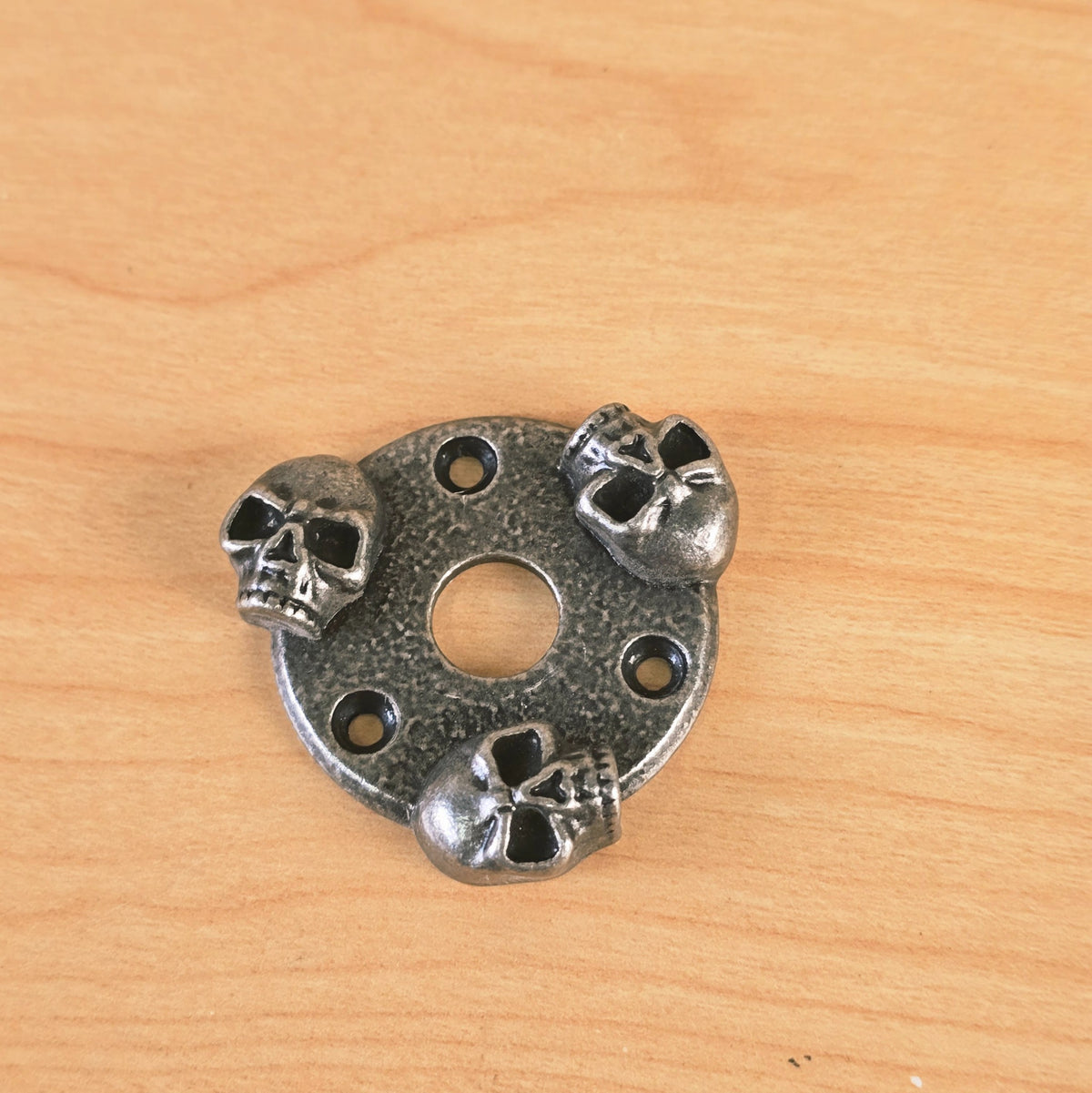 Top-down perspective view of the Gunther three-skull guitar accent plate.