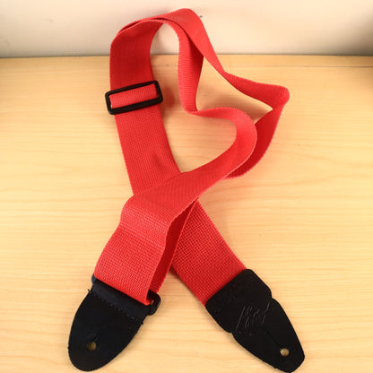 Full view of the red strap displaying both black leather ends and the plastic buckle.