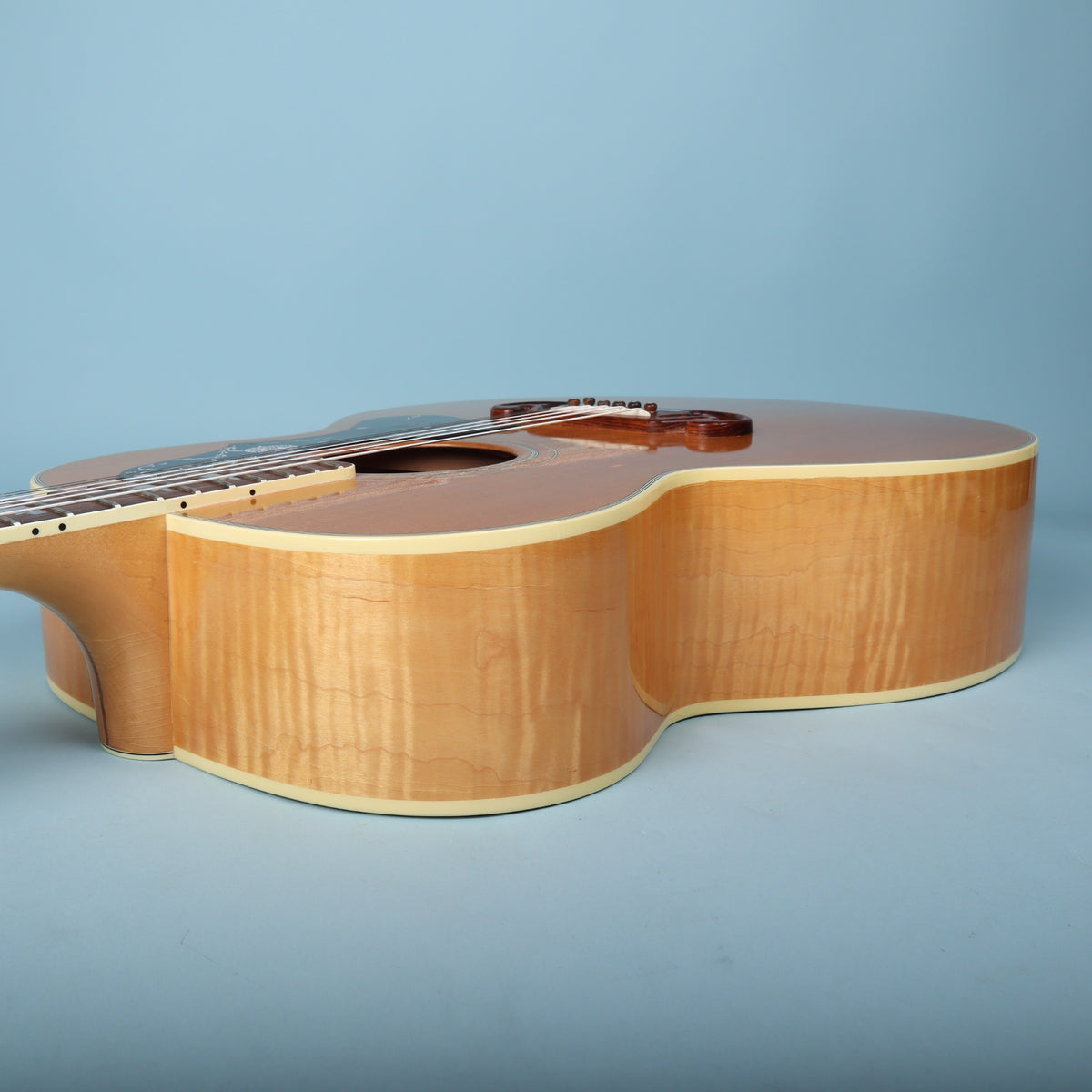Bass side profile view highlighting flame maple rim figure.