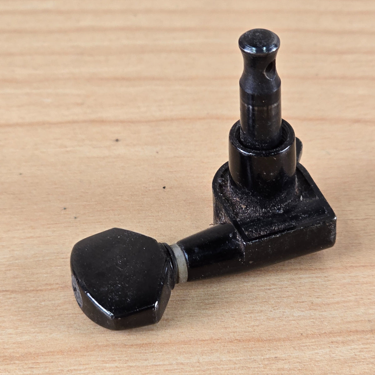 Side perspective view of the black Jackson tuning peg showing the button and post profile.