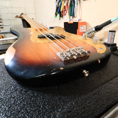 Low-angle view across the bridge and body towards the neck on the workbench.