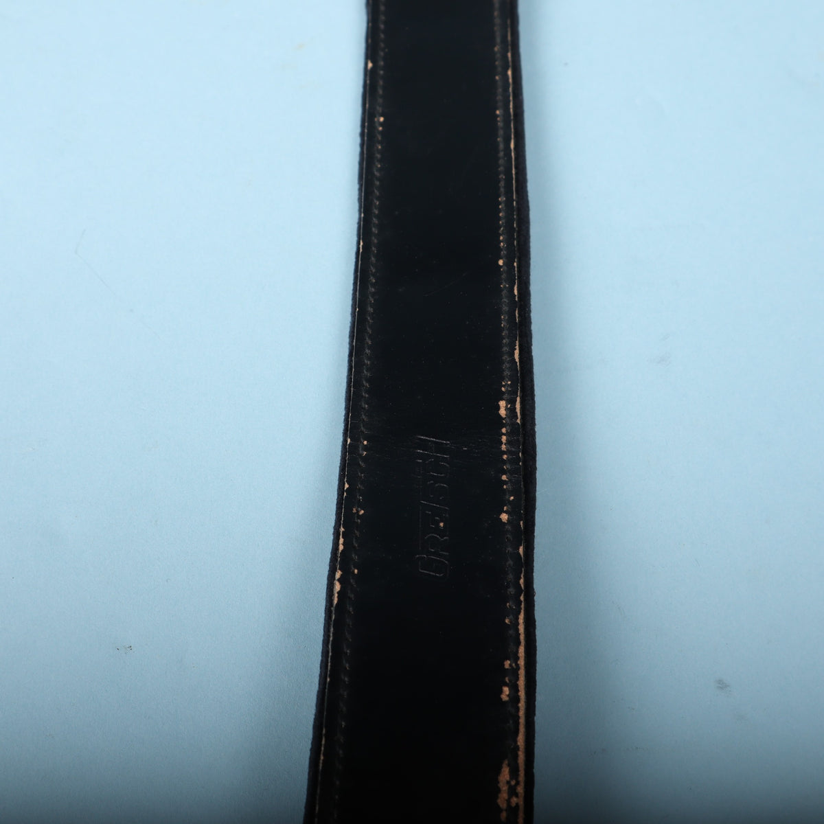 Gretsch embossed logo on black leather strap body.