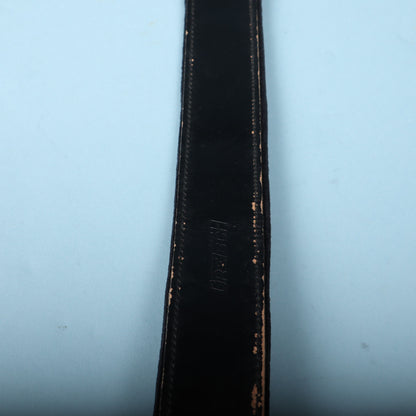 Gretsch embossed logo on black leather strap body.