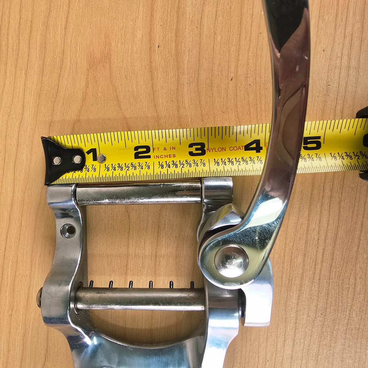 Measurement of the front roller assembly depth with a tape measure showing about 3 inches.