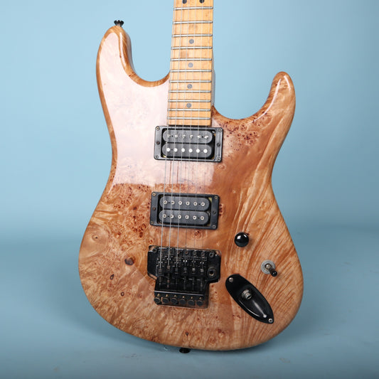 Front view of double-cutaway burl maple body with dual humbuckers.