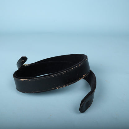 Gretsch black leather guitar strap end featuring strap button mounting slot.