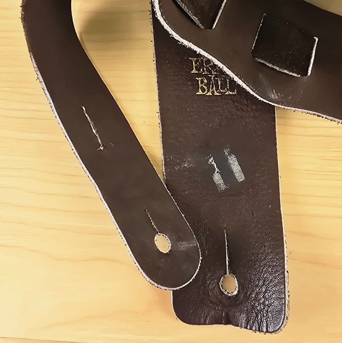 Close-up of the strap end and adjustment tail showing endpin slots