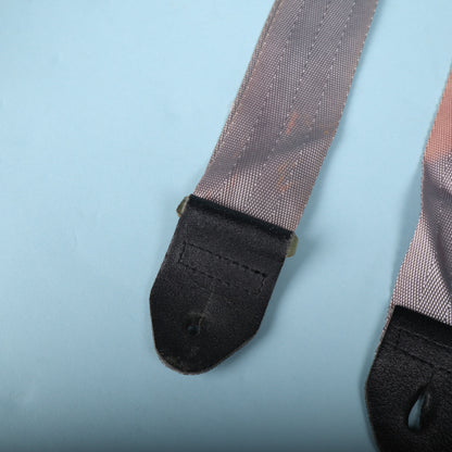Close-up of the opposite black leather strap end attached to the grey webbing.
