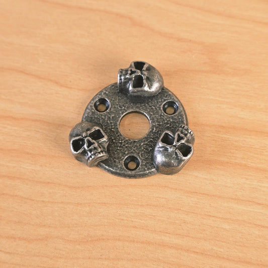 Gunther skull guitar plate angled view showing three sculpted skulls and mounting holes.
