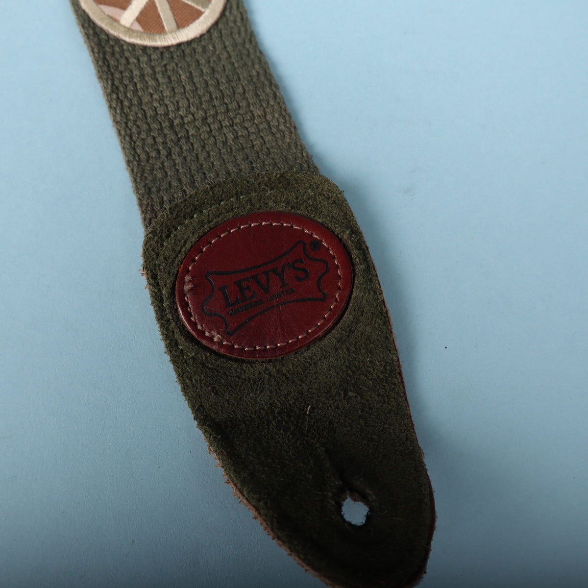 Close-up of the suede leather strap end with embossed Levy's leather logo badge