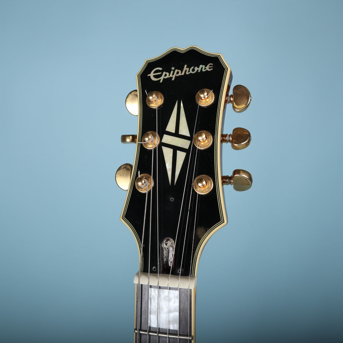 Front headstock view of Epiphone Les Paul Custom showing logo and split-diamond inlay