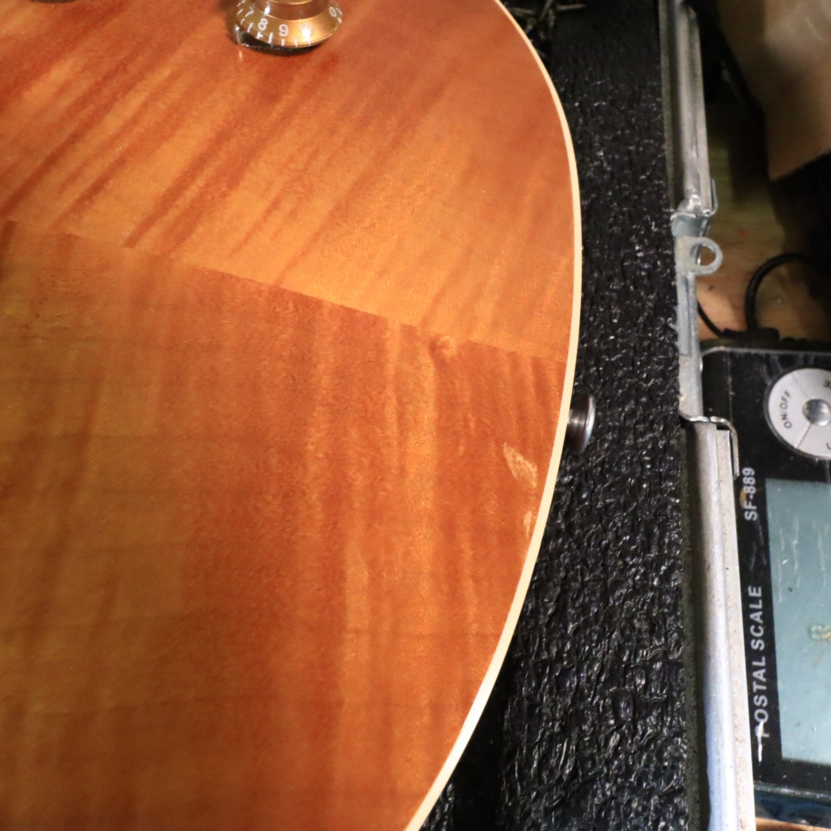 Close-up of small finish wear or ding on the lower edge of the maple top