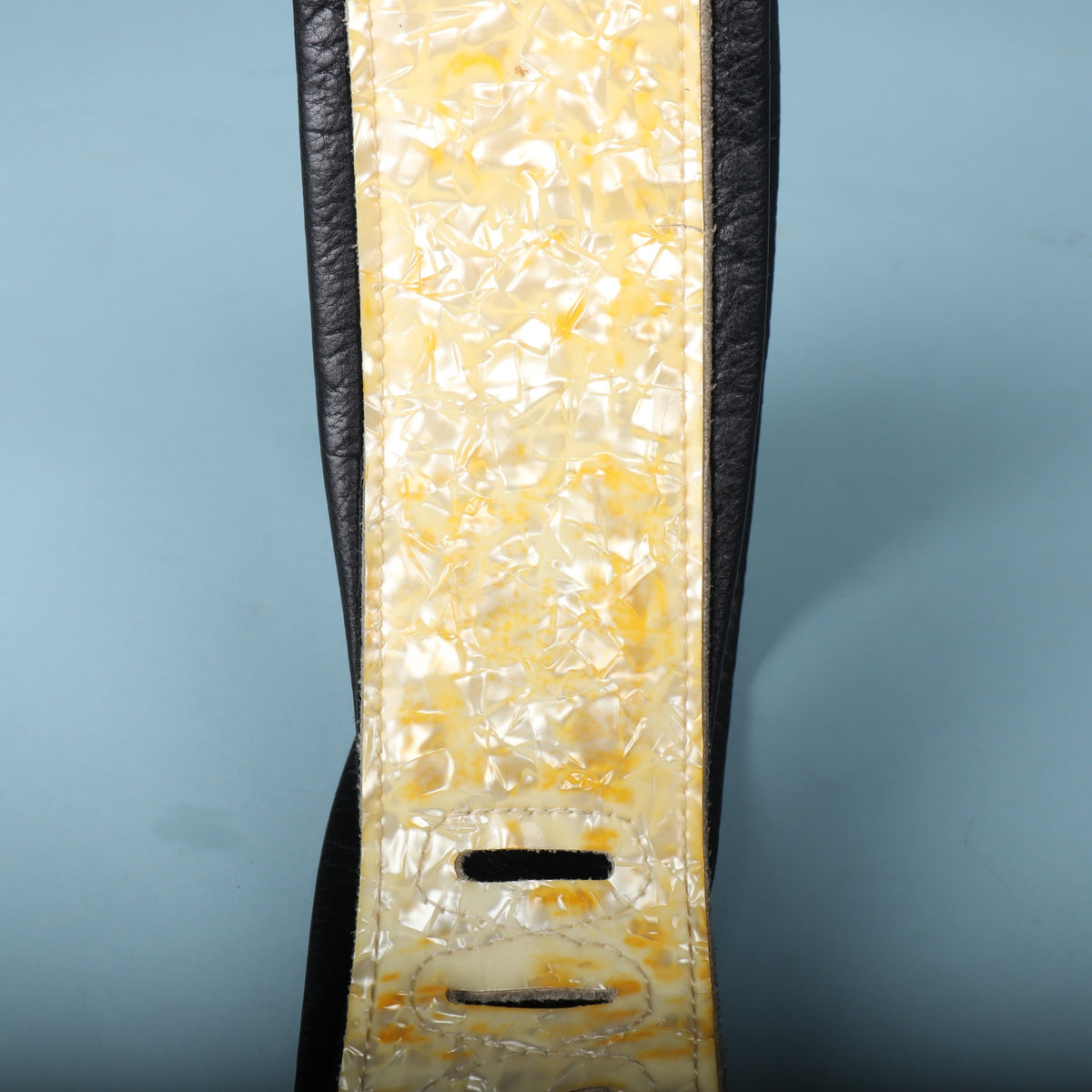 Detailed section of the padded body showing the pearloid inlay and ladder adjustment slots.