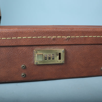 Detail of the brass-finish three-digit combination lock on the side of the Gibson case