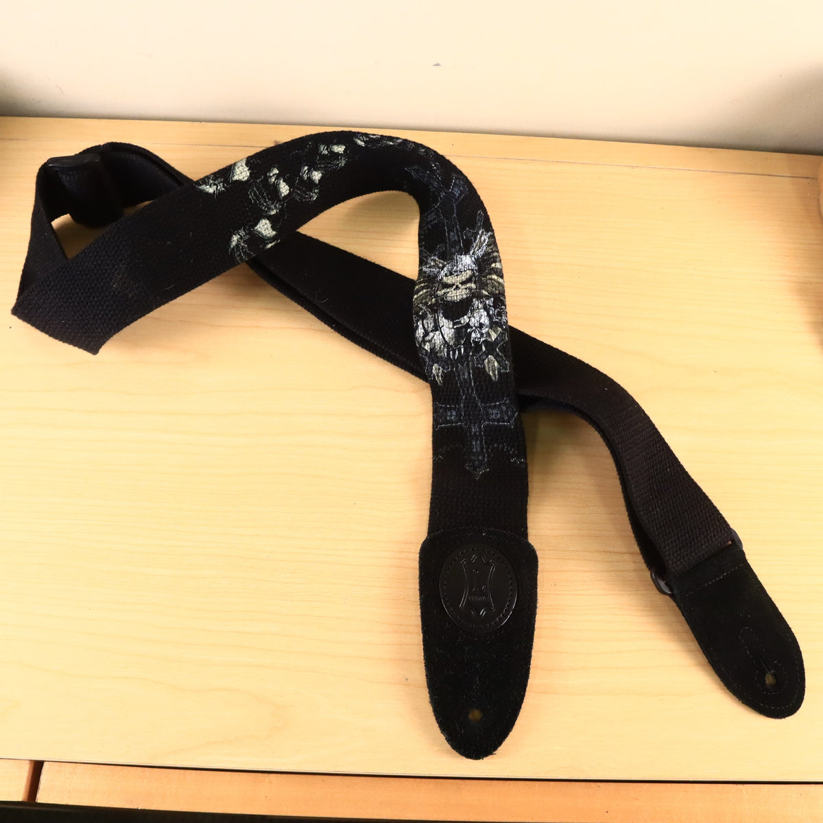 Full view of the Levy's guitar strap coiled loosely on a table.
