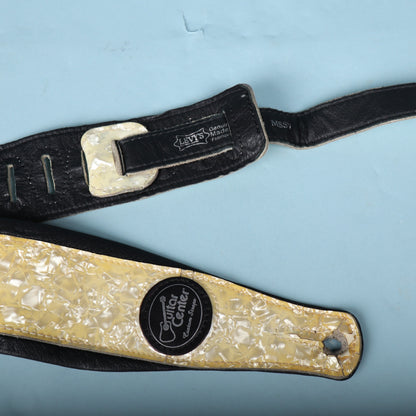 Close-up showing the feed-through loop, stamped brand tag, and lower end of the strap.