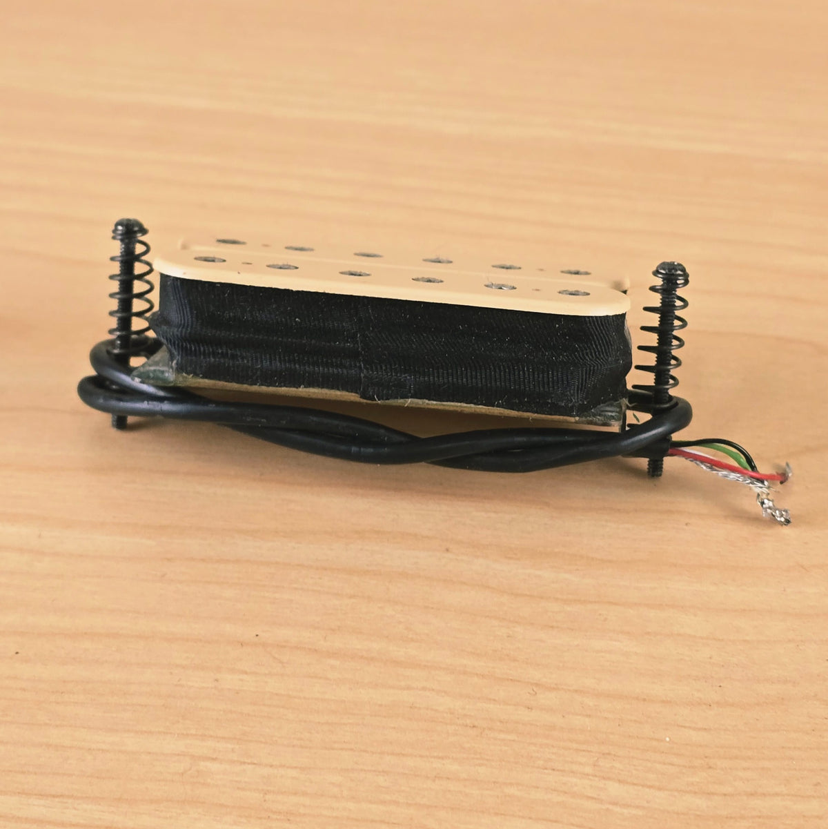 Side profile view showing pickup bobbin tape, baseplate, and mounting hardware