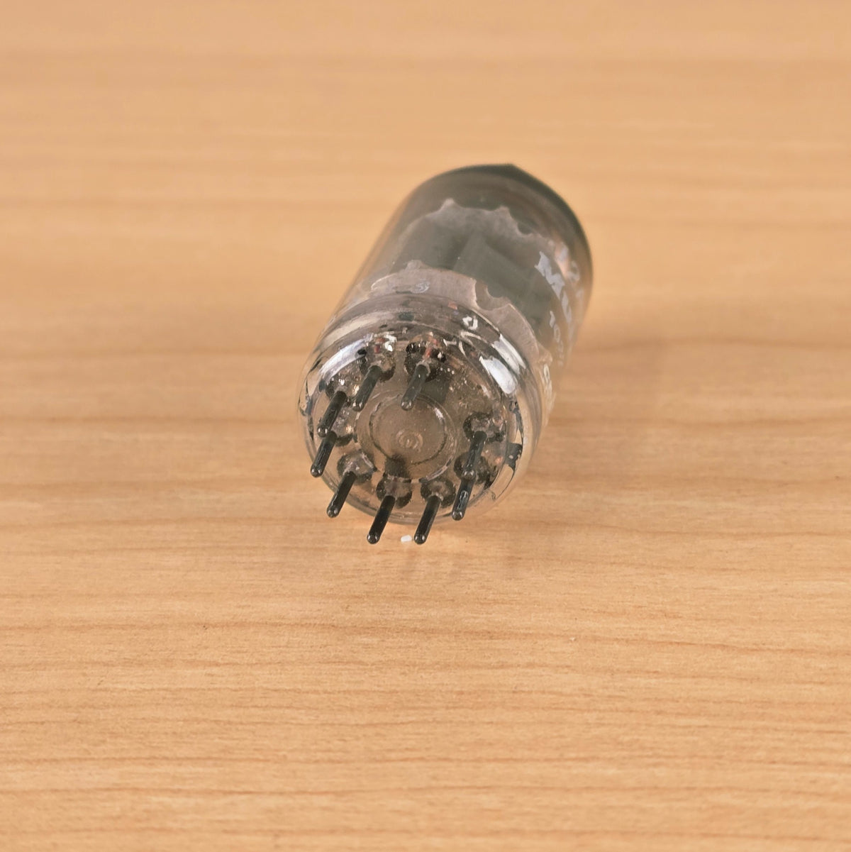 Bottom pin view of Mullard 12AX7A vacuum tube showing 9 pins.