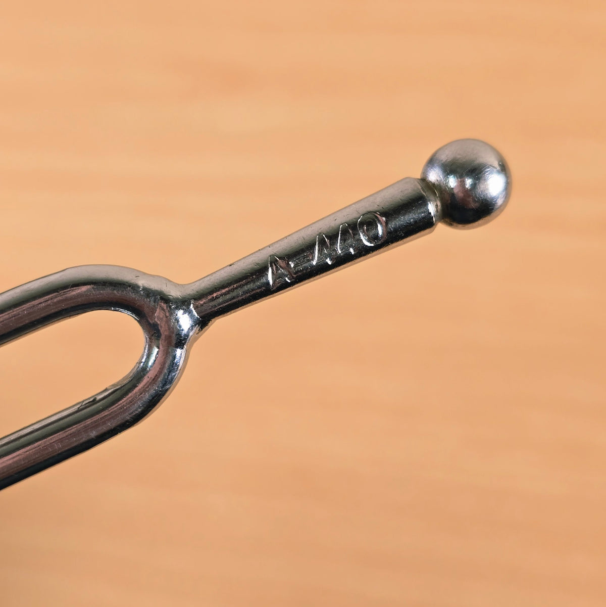 Close-up of the stem stamped A-440 on the tuning fork handle with ball end