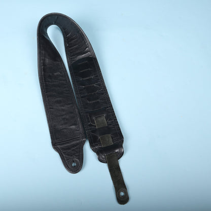 Underside view of the Action padded bass guitar strap showing the adjustment tail and slot system.