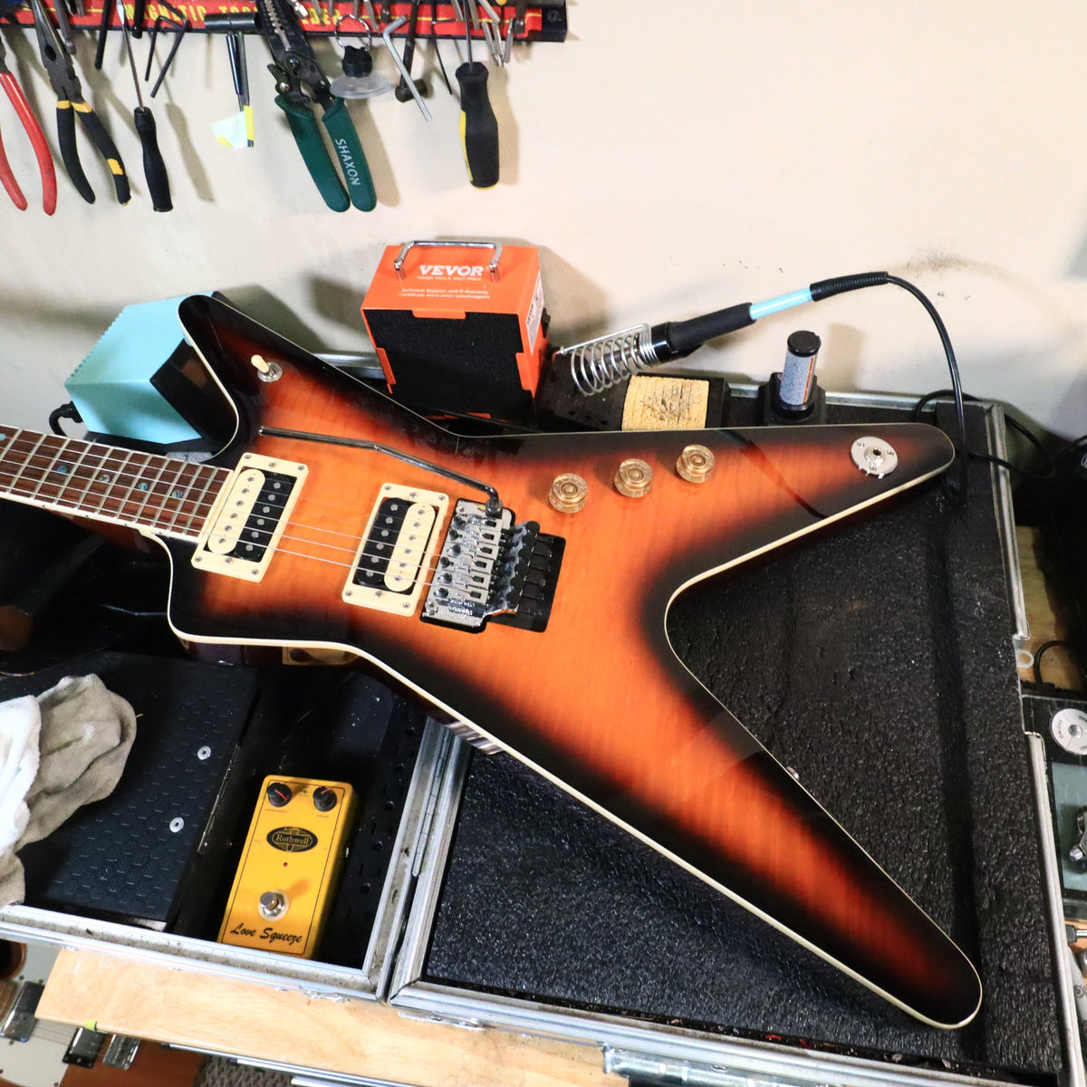 Dean ML body resting in open hardshell case on workbench