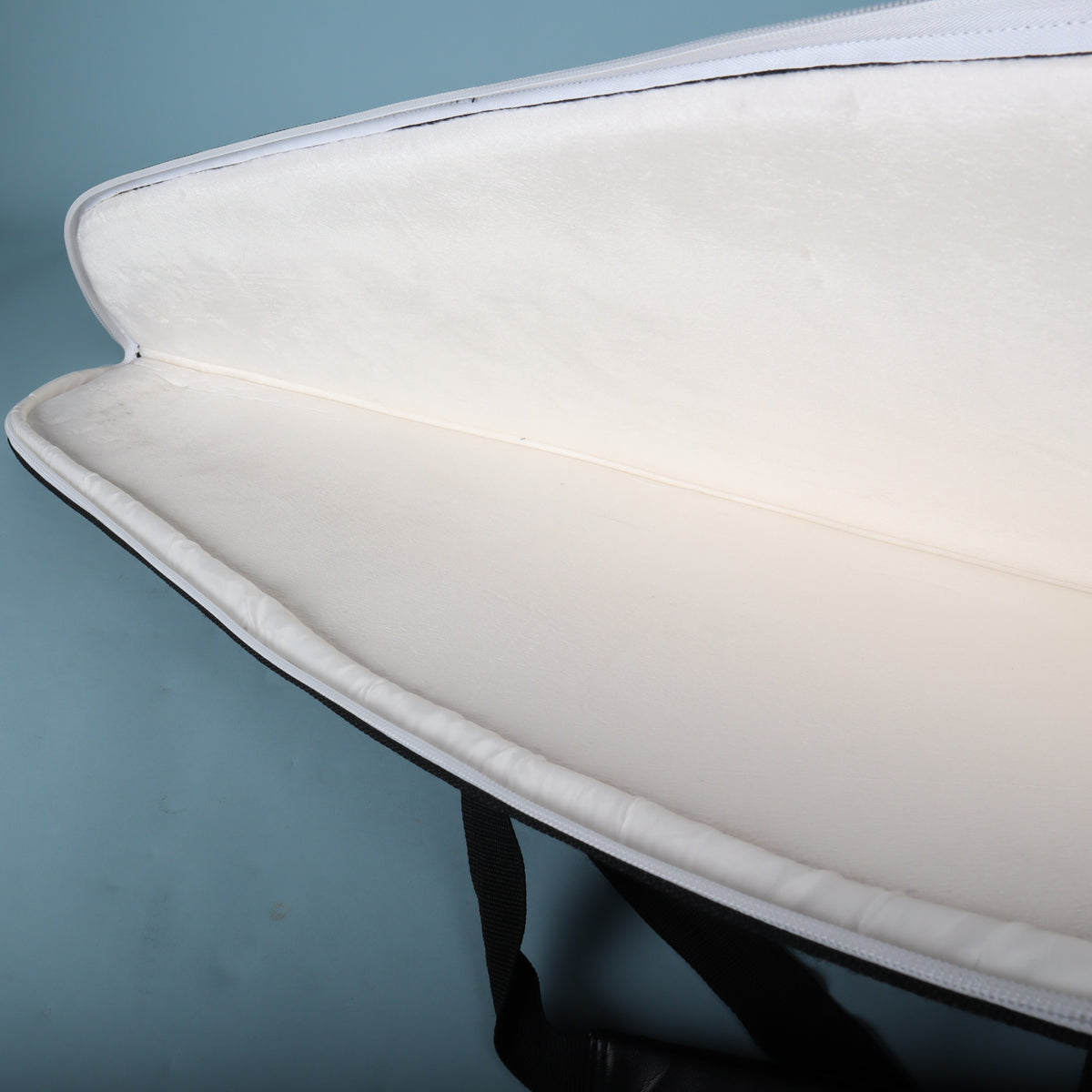 Interior view showing the full-length white plush padded lining and open zipper track.