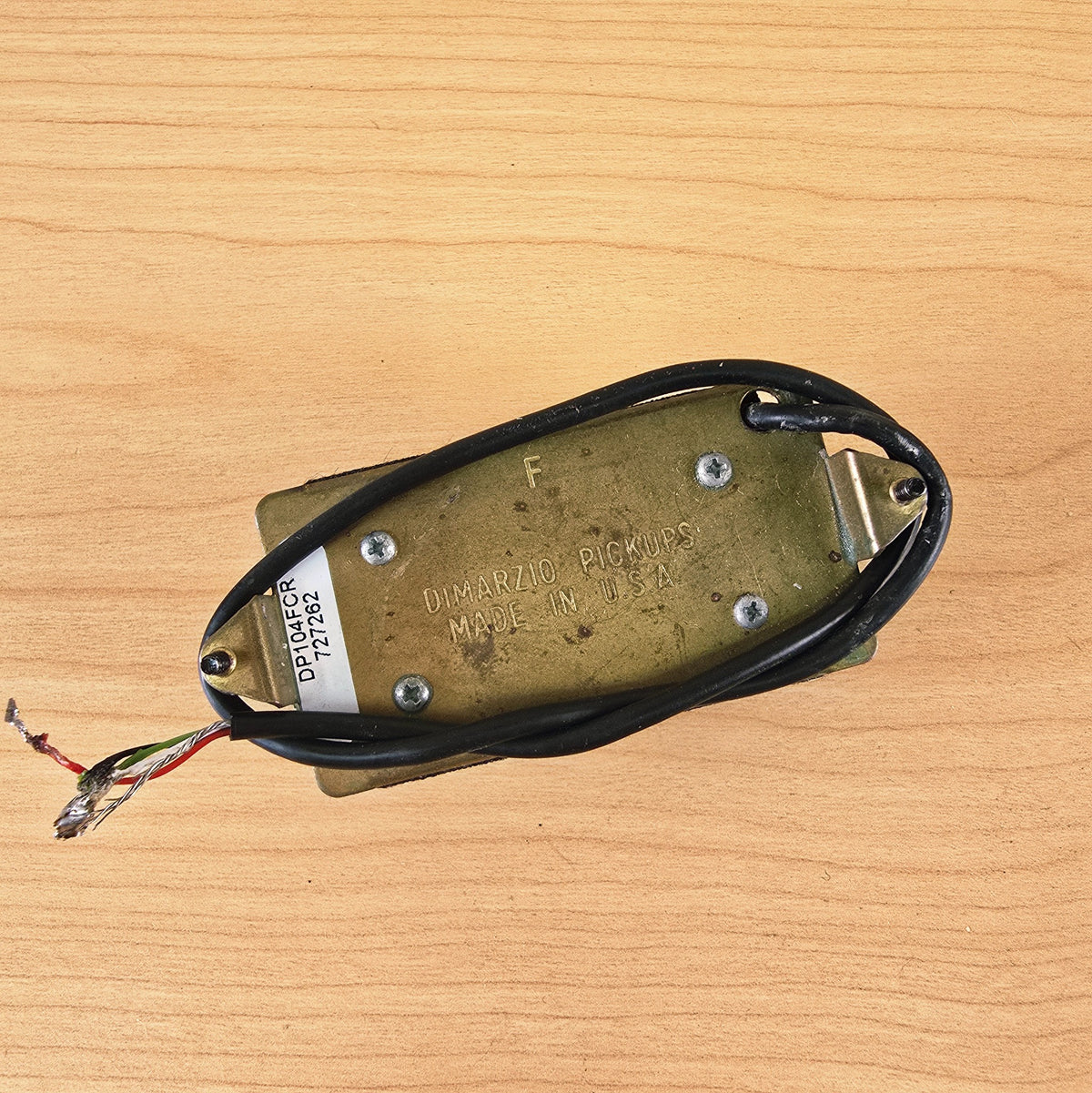 Brass baseplate of DiMarzio pickup showing DP104FCR label, F stamp, and wiring