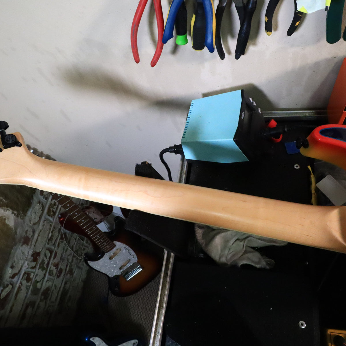 Rear view of maple neck shaft resting on workbench