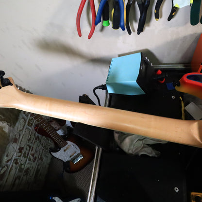 Rear view of maple neck shaft resting on workbench