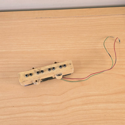 Top view of a cream 4-string bass pickup with green and red lead wires.